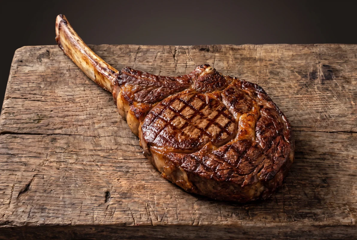 Savršeno pečen Wagyu tomahawk steak s grill markicama na rusticnoj drvenoj dasci